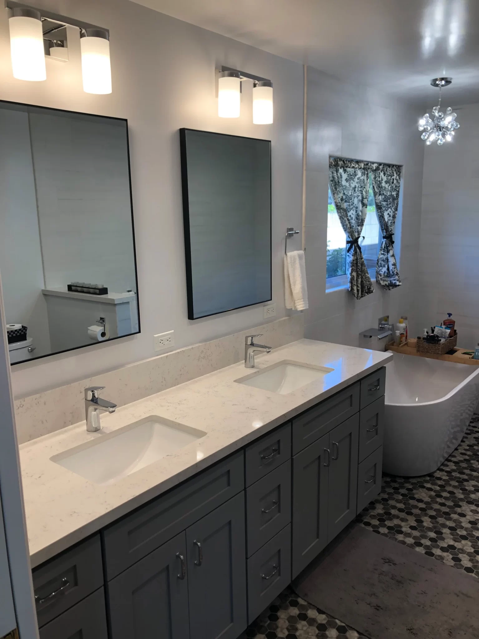 bathroom-remodels-7 Modern bathroom with double sinks, large mirrors, a freestanding tub, and patterned tile floor.