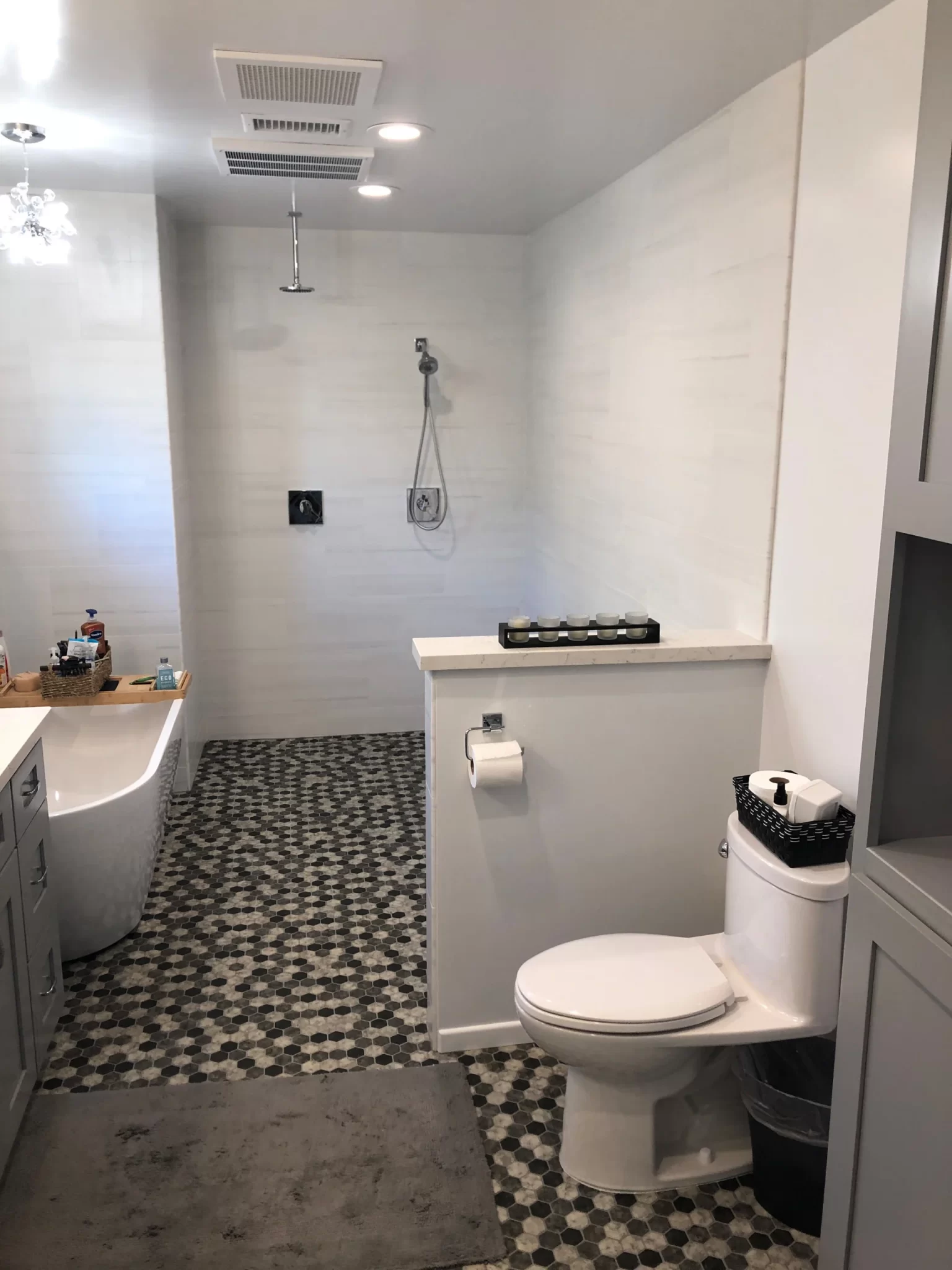 bathroom-remodels-8 Modern bathroom with a bathtub, open shower, toilet, and patterned tile floor.