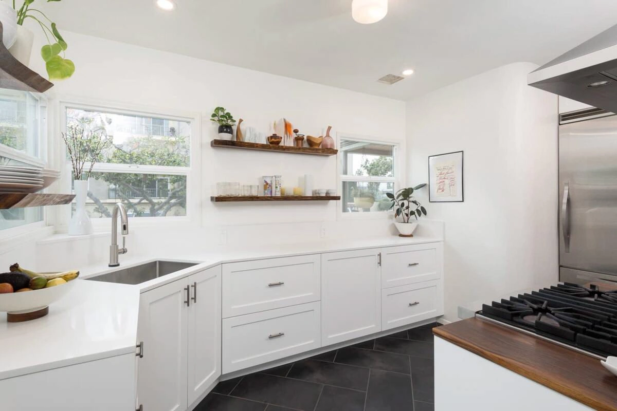 custom-cabinetry-carpentry-17 Bright, modern kitchen with white cabinets, open shelves, and stainless steel appliances.