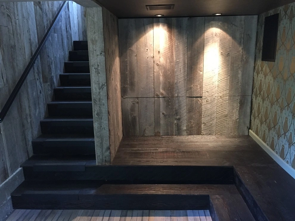 custom-cabinetry-carpentry-8 Modern interior with dark wooden stairs, wood-paneled walls, and spotlights illuminating the corner.